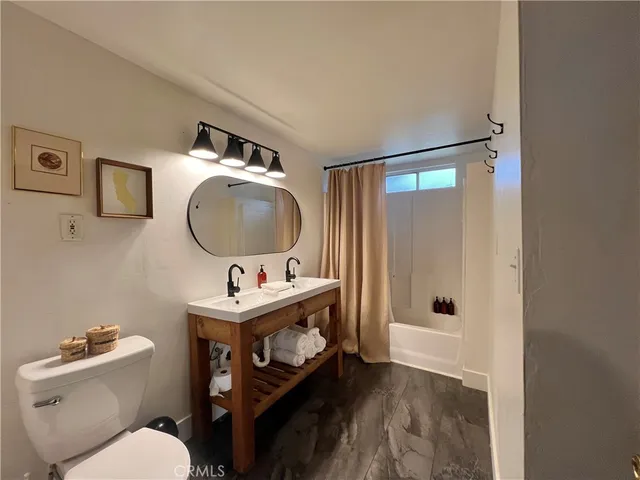 a bathroom with a toilet sink vanity tub and mirror