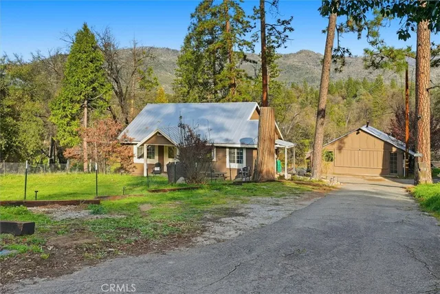 a view of a big house with a big yard and large trees