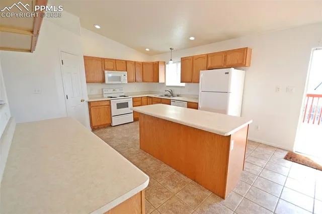 a large kitchen with kitchen island a sink a stove and a refrigerator
