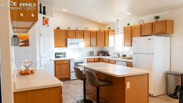 a kitchen with a sink a refrigerator and white cabinets