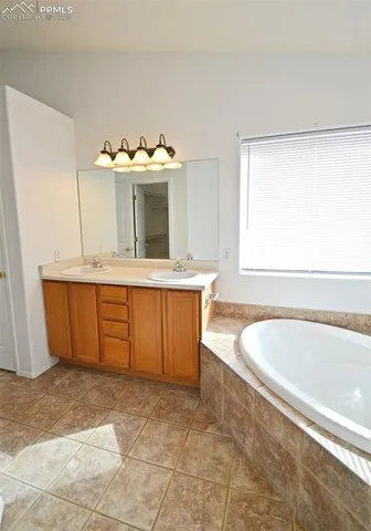a spacious bathroom with a tub sink and mirror