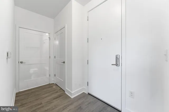 a view of empty room with wooden floor