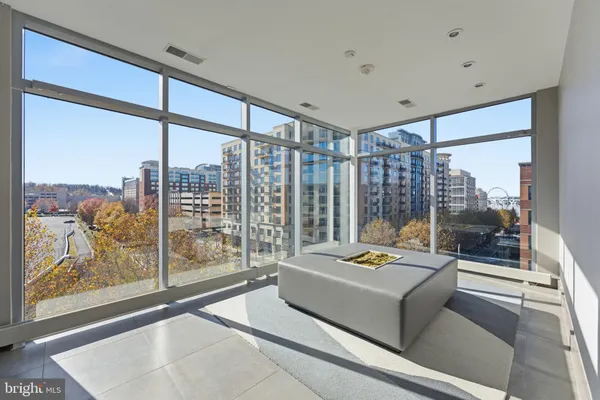 a living room with furniture and a floor to ceiling window