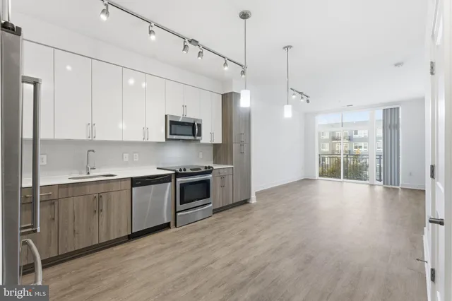a large kitchen with stainless steel appliances granite countertop a stove and a refrigerator