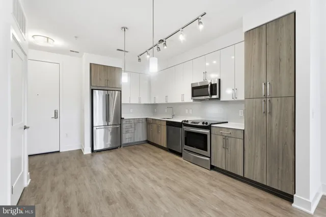 a kitchen with stainless steel appliances a refrigerator and a stove top oven