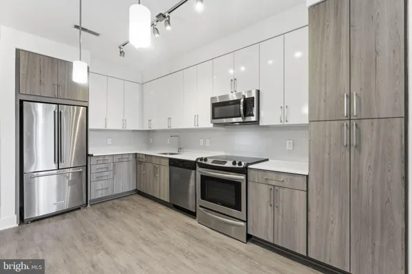 a kitchen with stainless steel appliances a refrigerator sink and microwave