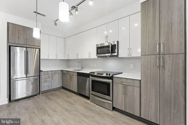 a kitchen with stainless steel appliances a refrigerator sink and microwave
