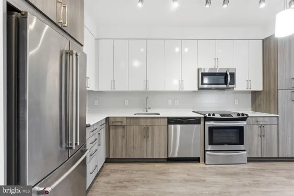 a kitchen with stainless steel appliances granite countertop a stove a sink and a refrigerator