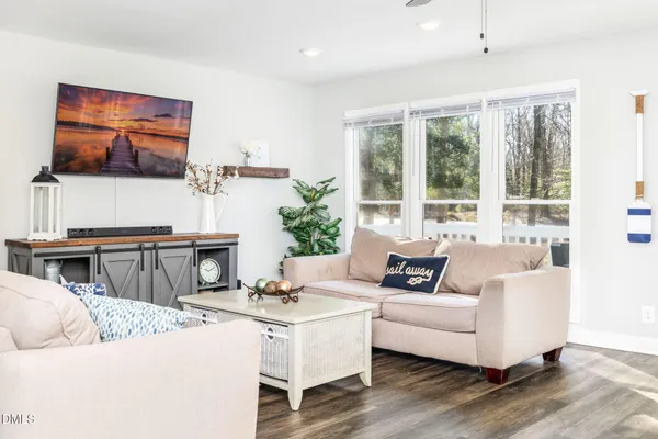 a living room with furniture dining table a lamp and a window