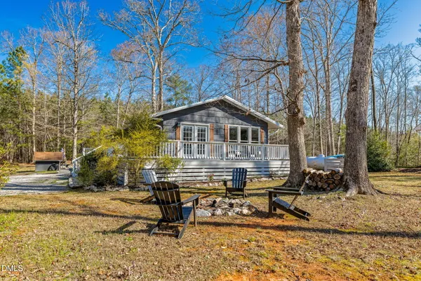 a view of a house with a yard chairs and floor to ceiling window