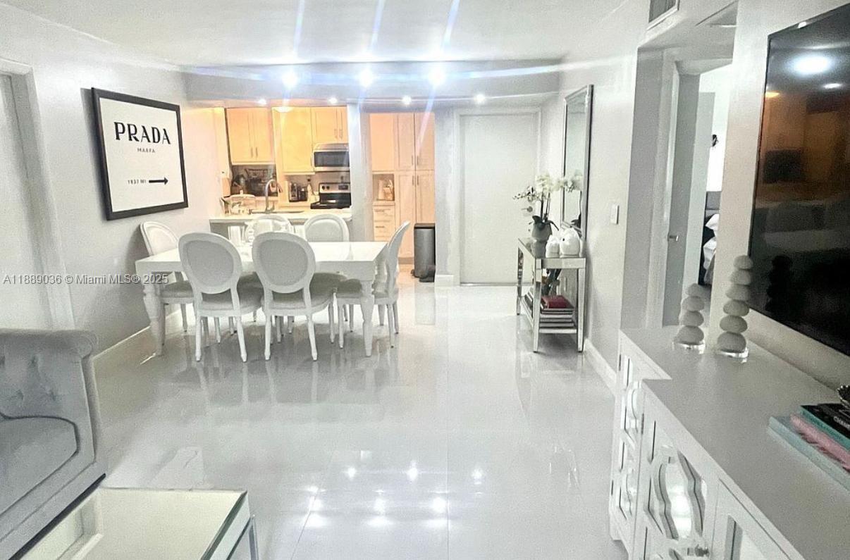 9710 Hammocks Boulevard, Unit 10331 Miami, FL 33196 - Photo 6 of 17 a dining room with furniture a painting and a chandelier