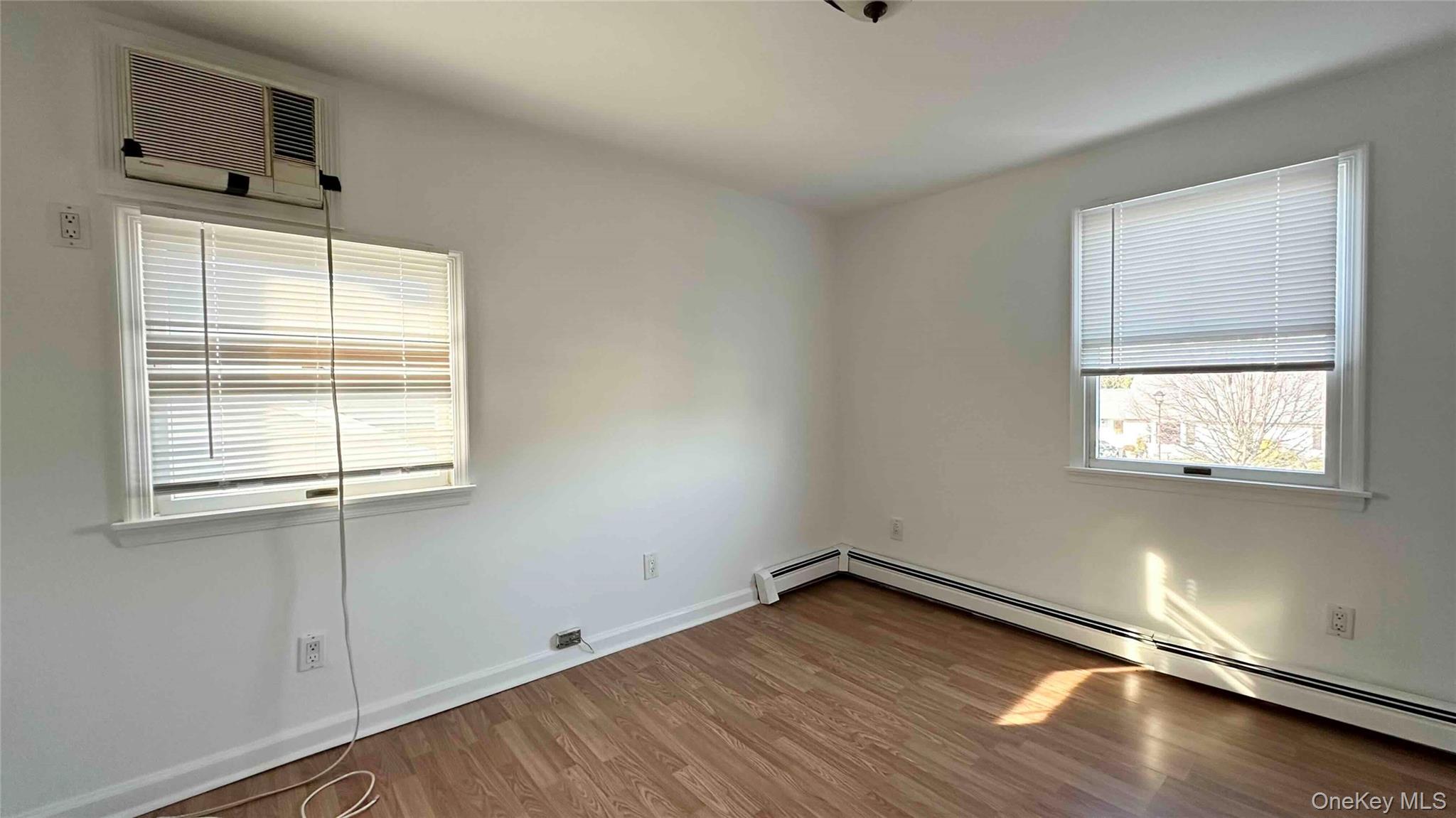 34 Marksman Lane Levittown, NY 11756 - Photo 11 of 15 an empty room with wooden floor and windows