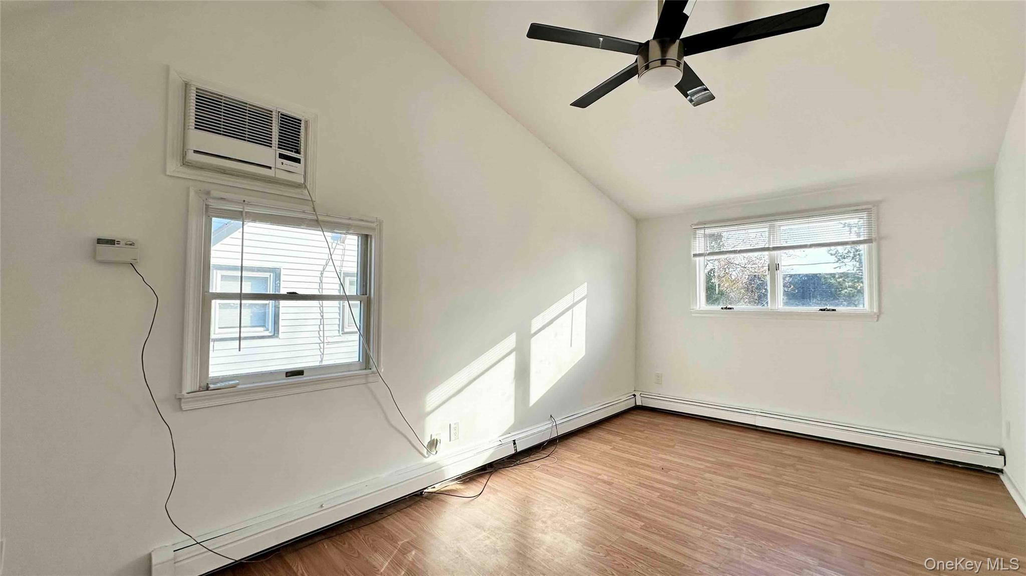 34 Marksman Lane Levittown, NY 11756 - Photo 7 of 15 a view of an empty room with a window and wooden floor