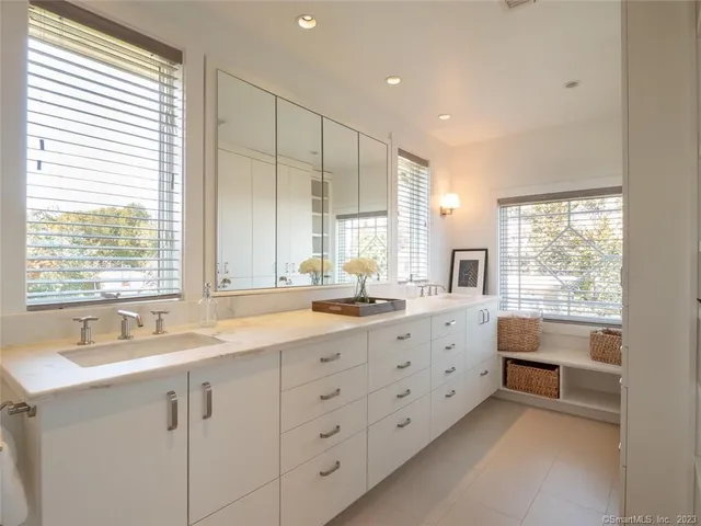 a bathroom with double vanity sink a mirror a window and vanity