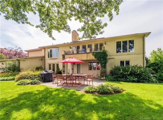 a front view of a house with garden and sitting area