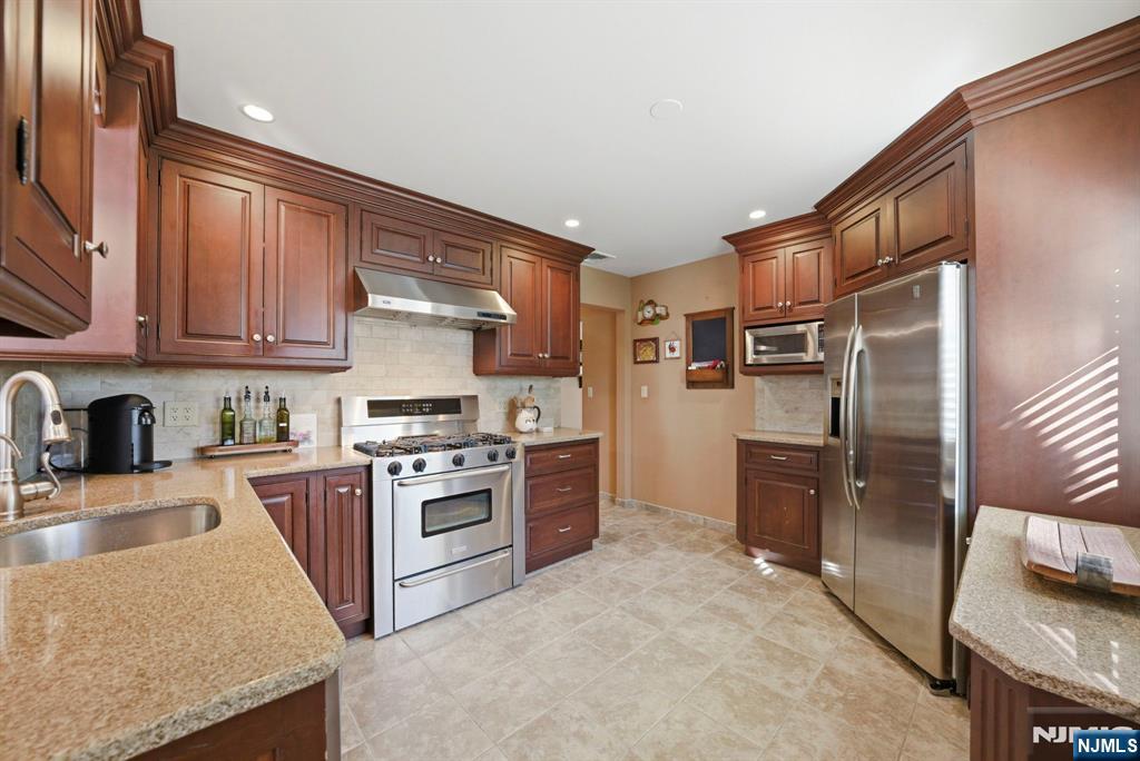 24 Maple Avenue Waldwick, NJ 07463 - Photo 22 of 45 a kitchen with stainless steel appliances granite countertop a stove top oven a sink and dishwasher