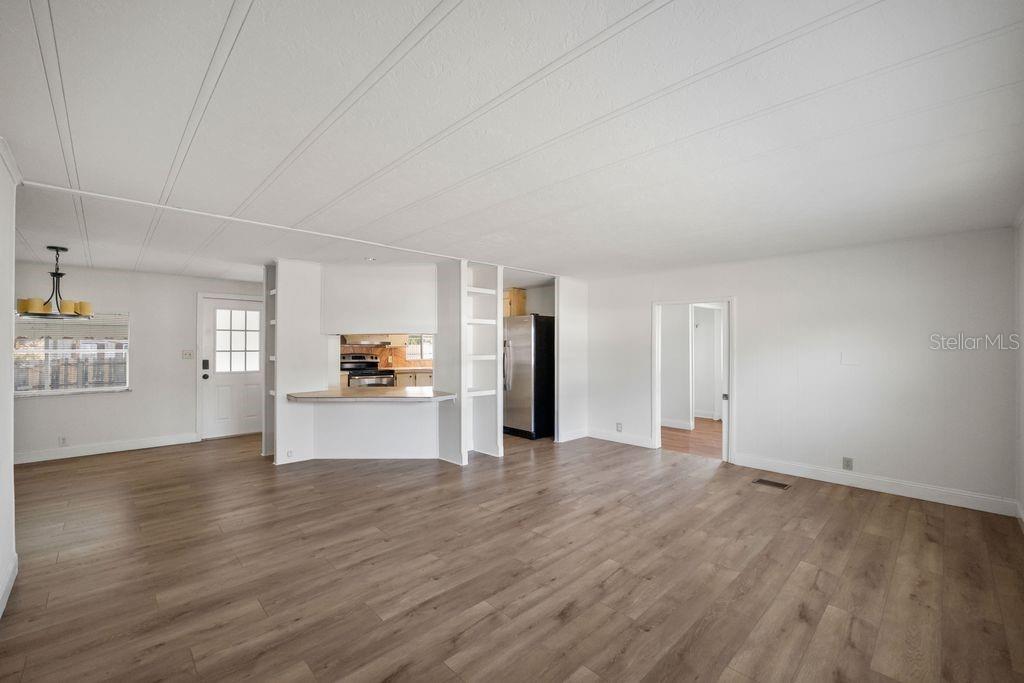 3648 Fox Ridge Boulevard Wesley Chapel, FL 33543 - Photo 24 of 30 a view of a big room with wooden floor and a kitchen