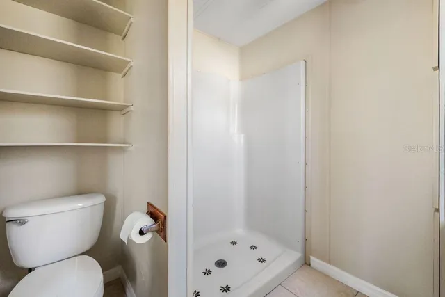 a bathroom with a toilet and a shower