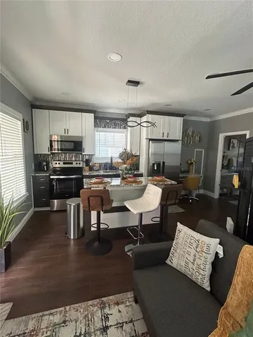 a open kitchen with stainless steel appliances granite countertop a stove a sink a dining table and chairs