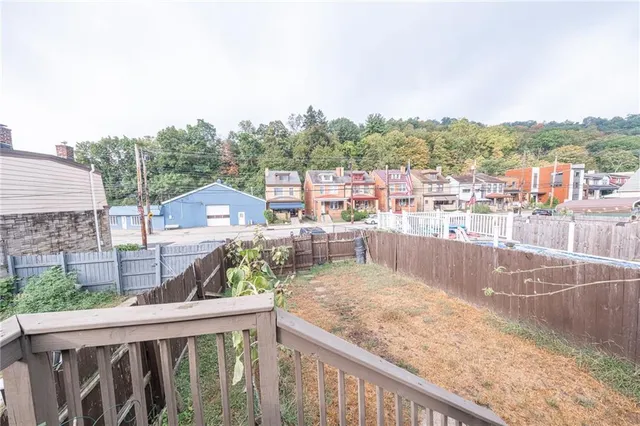 a view of a white house with large windows and a table and chairs
