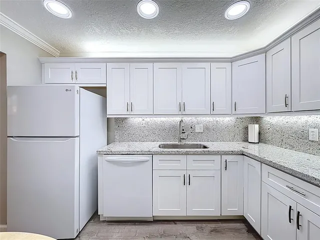 a kitchen with stainless steel appliances granite countertop a refrigerator sink and cabinets