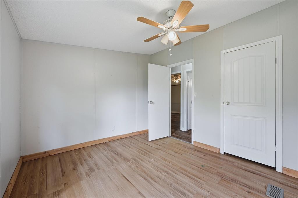 150 Gilbreath Road Sadler, TX 76264 - Photo 19 of 34 an empty room with wooden floor and a ceiling fan