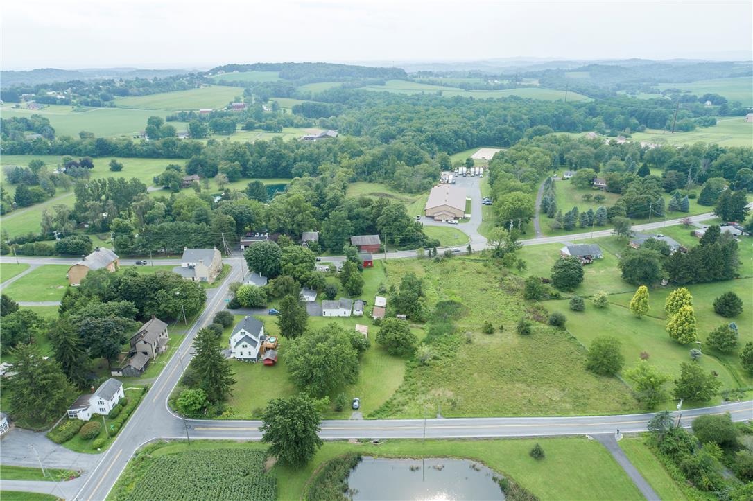 665 Point Phillips Road Bath, PA 18014 - Photo 70 of 73 Vast, verdant landscape unfolds with scattered homes, winding roads, and a tranquil pond, inviting serene country living.