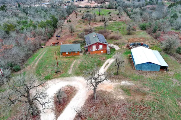 an aerial view of a house with a yard and lake