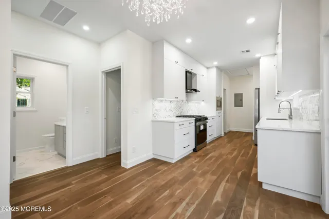 a large kitchen with kitchen island a sink stainless steel appliances and cabinets