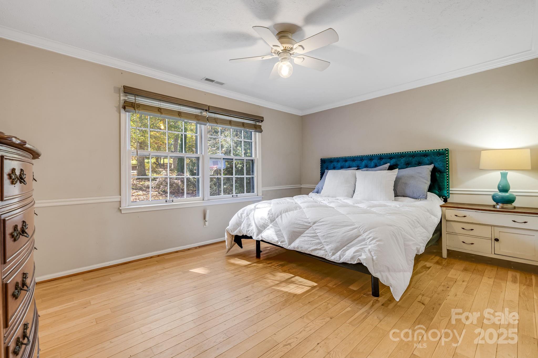 203 Davis Mountain Road Laurel Park, NC 28739 - Photo 13 of 37 a bedroom with a large bed and a chandelier