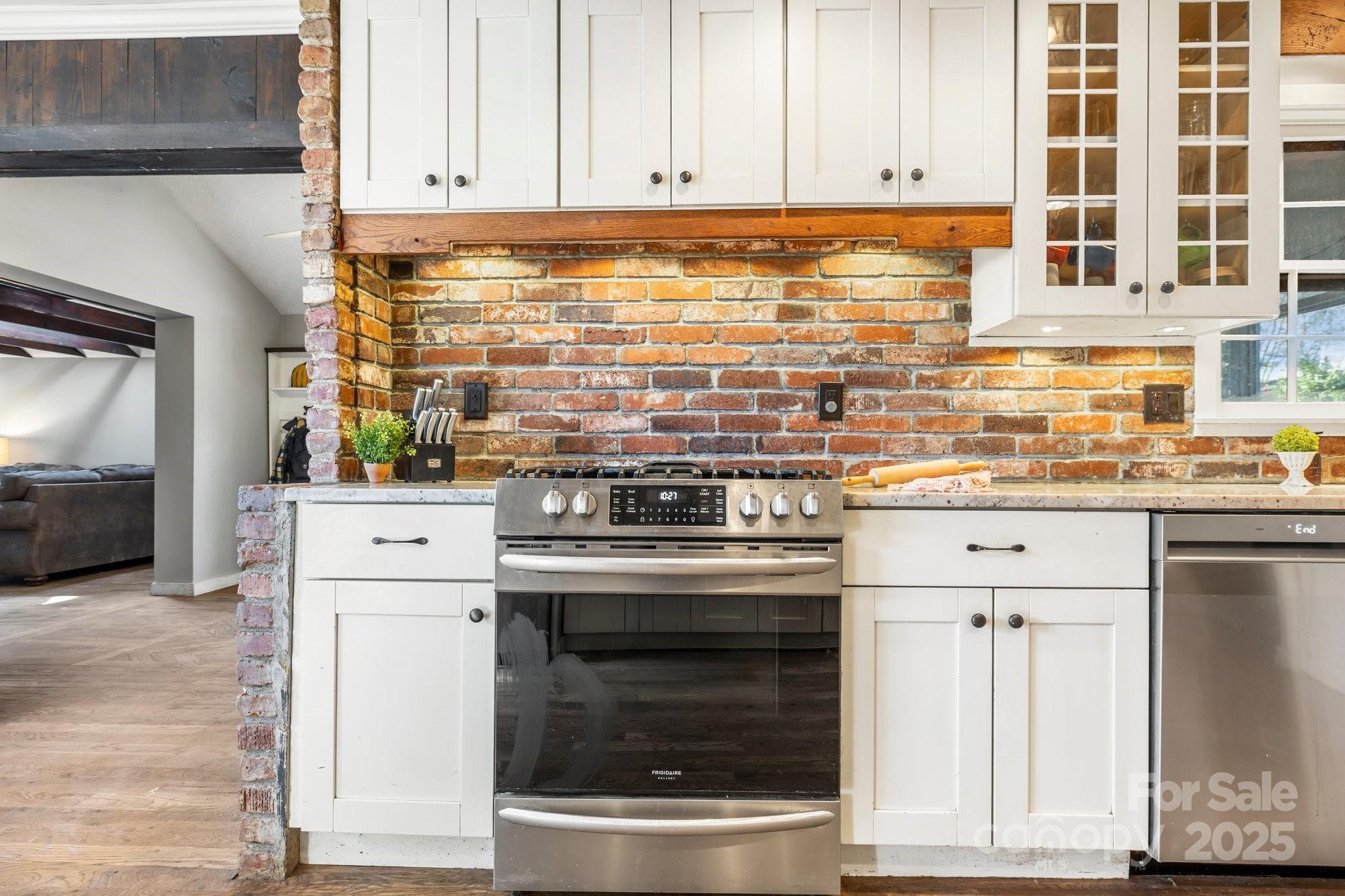 203 Davis Mountain Road Laurel Park, NC 28739 - Photo 7 of 37 a kitchen with granite countertop white cabinets and stainless steel appliances