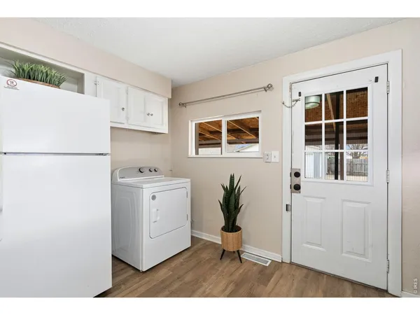 a kitchen with a refrigerator and white cabinets