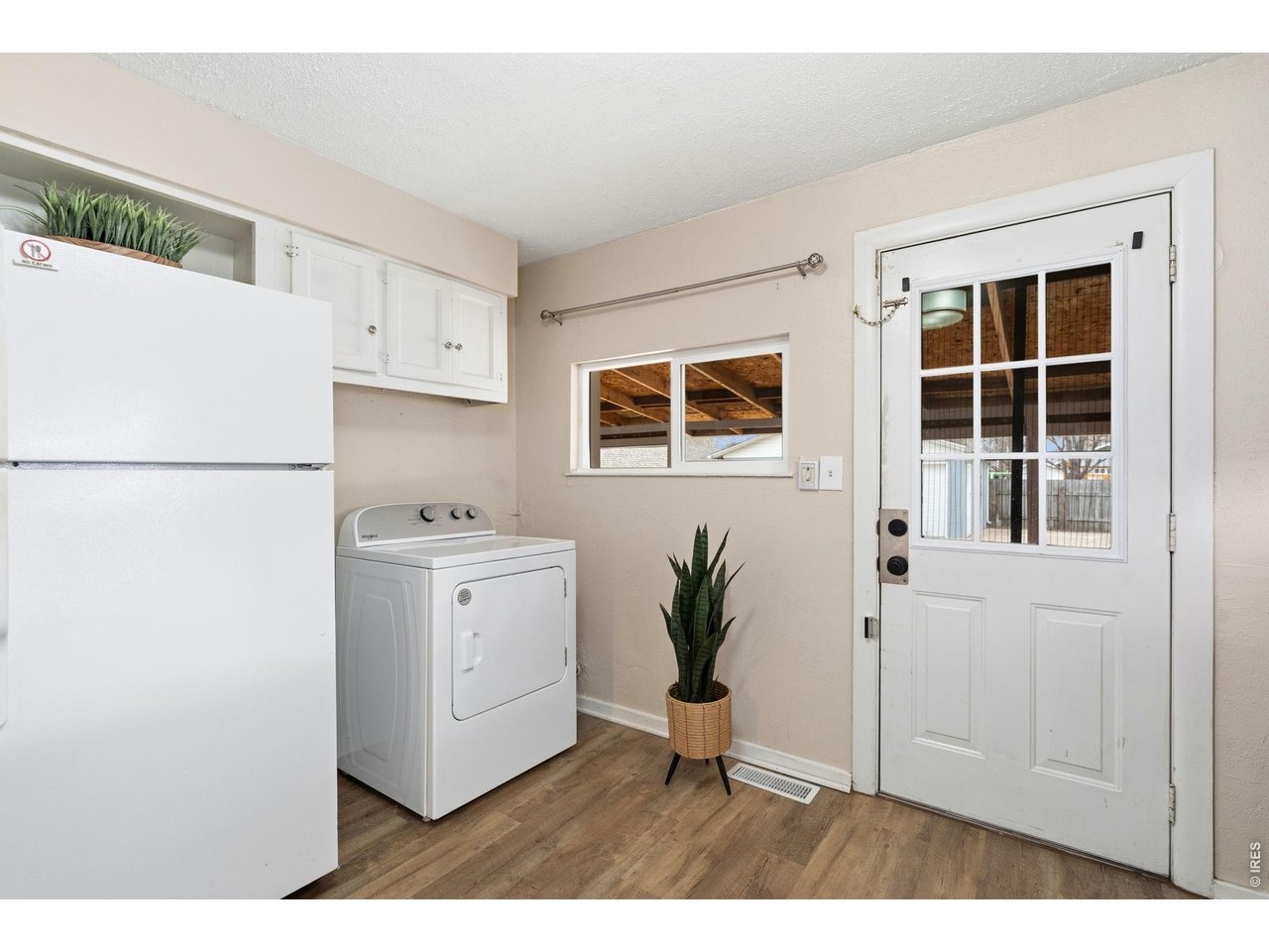 1416 6th Street Greeley, CO 80631 - Photo 12 of 50 a kitchen with a refrigerator and white cabinets