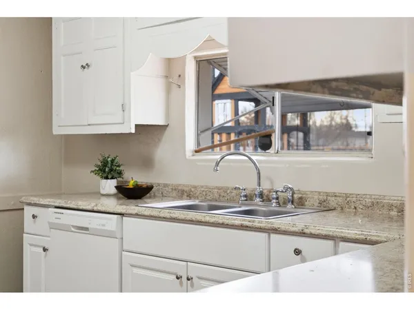 a kitchen with granite countertop a sink stainless steel appliances and cabinets