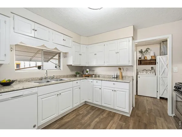 a kitchen with granite countertop white cabinets and white appliances