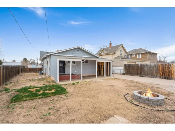 a view of a house with backyard and wooden fence