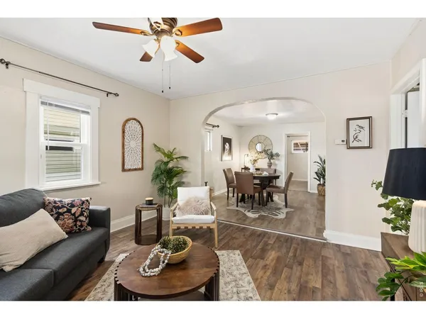 a living room with furniture a dining table and a chandelier