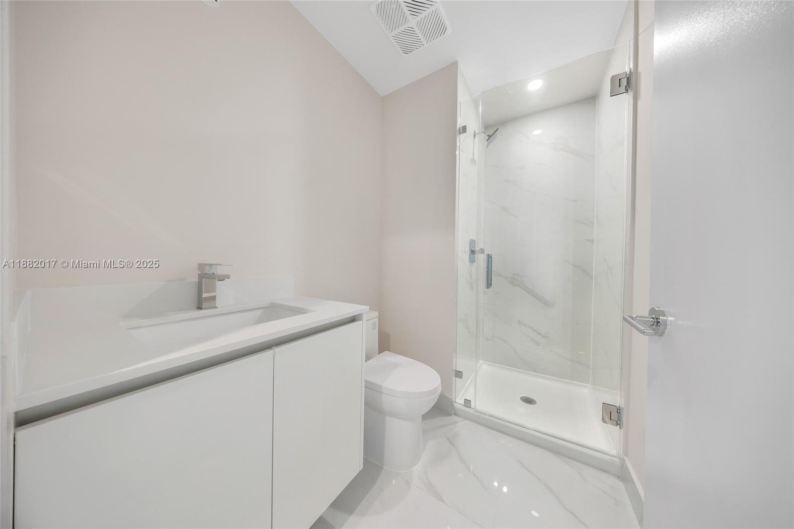 700 Northeast 24th Street, Unit 502 Miami, FL 33137 - Photo 11 of 25 a bathroom with a shower sink vanity and toilet