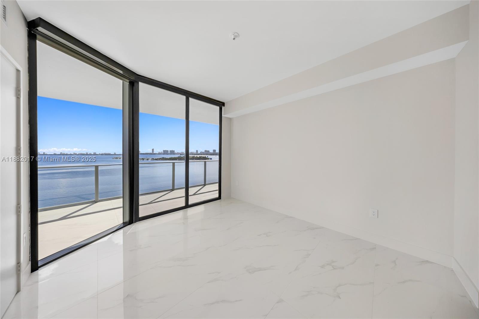 700 Northeast 24th Street, Unit 502 Miami, FL 33137 - Photo 20 of 25 an empty room with sliding glass door and glass door