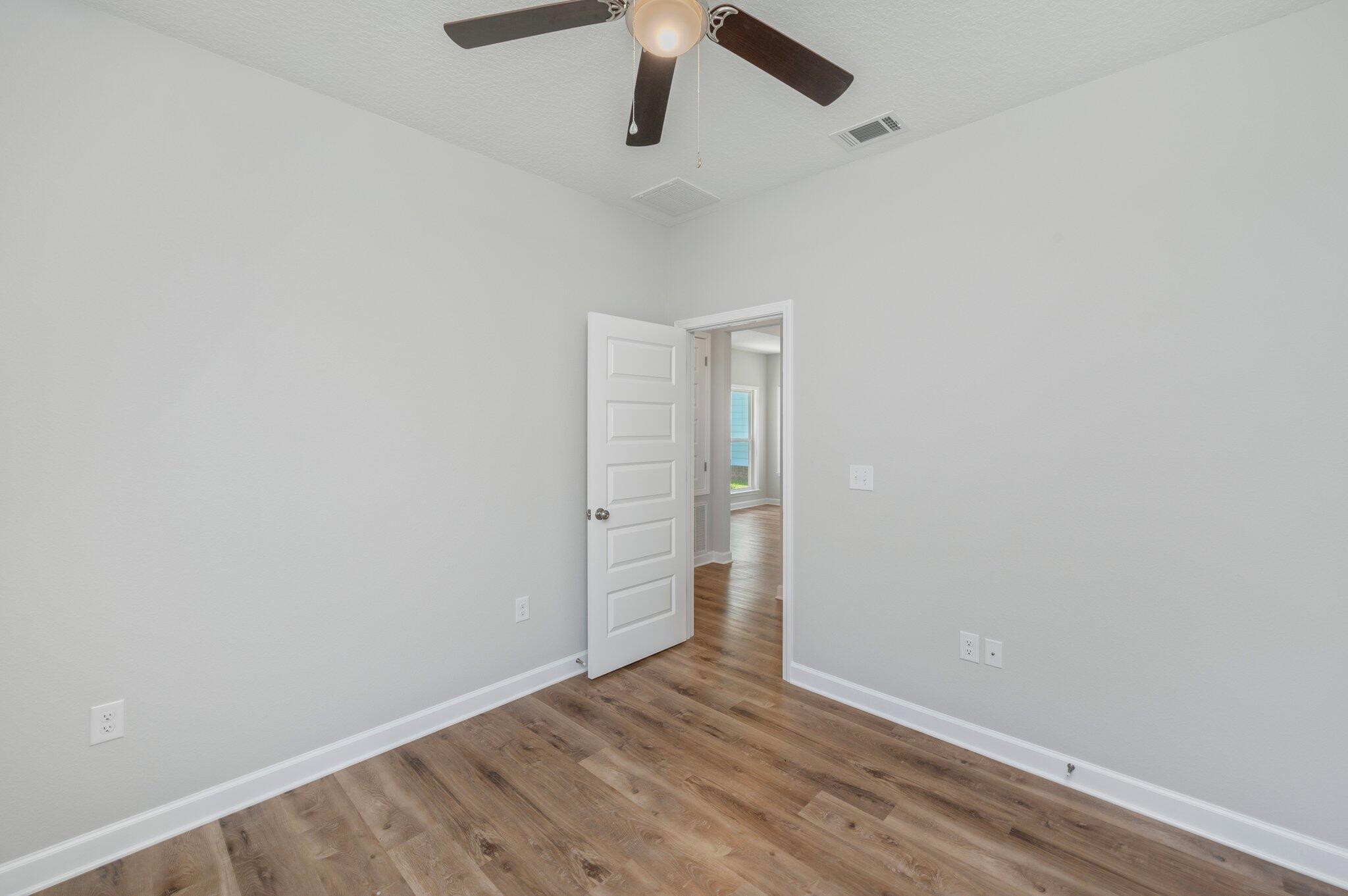 73 Lafayette Creek Freeport, FL 32439 - Photo 23 of 38 an empty room with wooden floor and ceiling fan