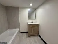 a bathroom with a tub sink and mirror
