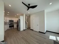 a view of empty room with wooden floor and ceiling fan