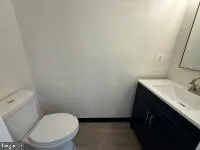 a bathroom with a toilet a sink and mirror