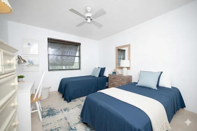 a bedroom with two beds and painting on the wall