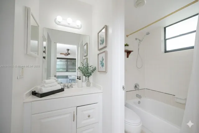 a bathroom with a granite countertop sink a toilet and shower