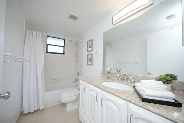 a bathroom with a granite countertop sink a toilet and shower