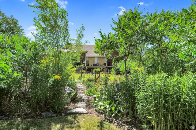 510 Spring Creek Road Providence, UT 84332 - Photo 76 of 97 Expansive backyard path featuring natural stone pavers surrounded by mature plantings and diverse foliage