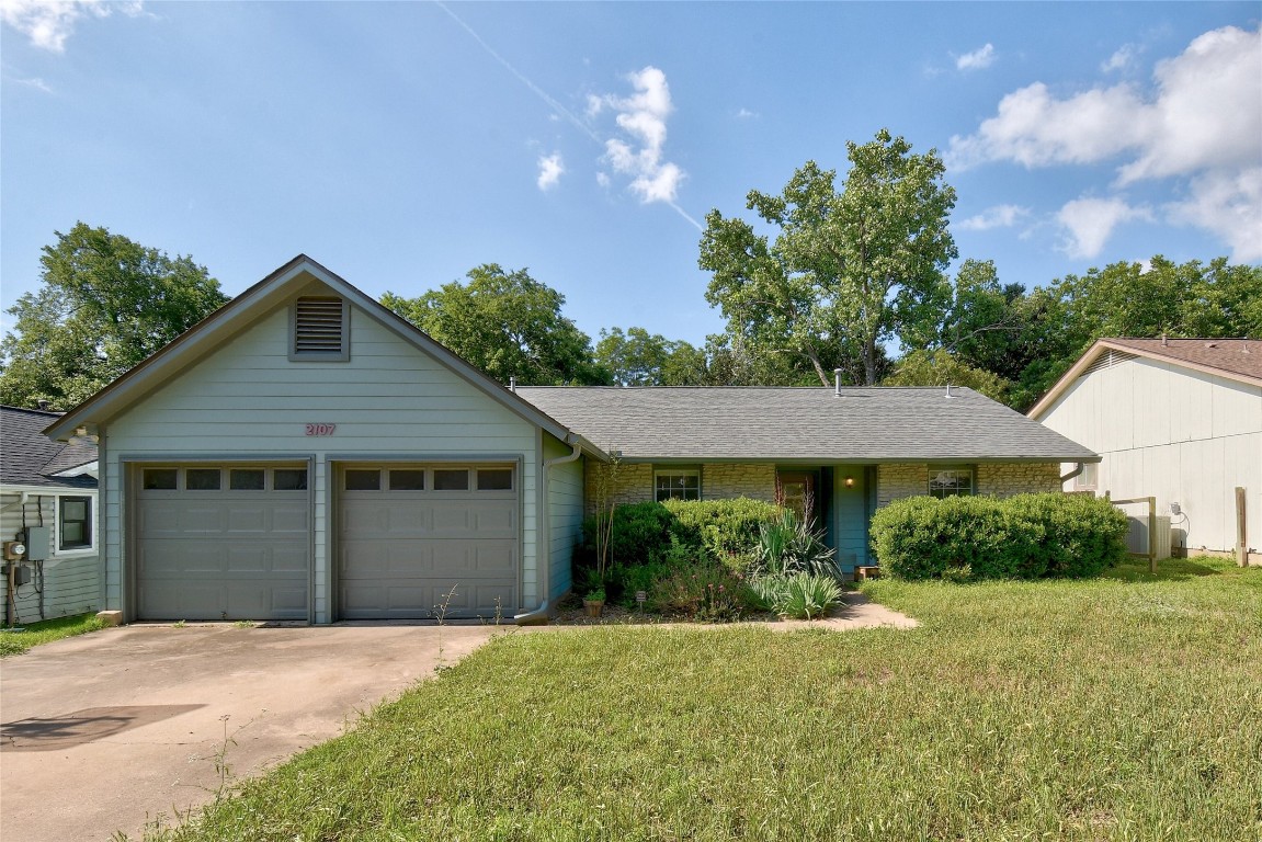 a front view of a house with a yard and garage