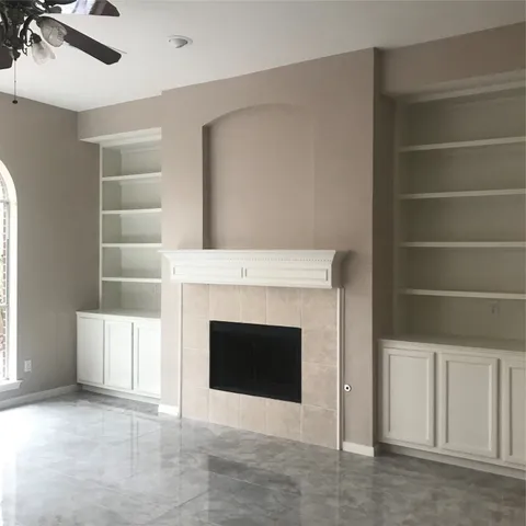 a living room with a fireplace cabinet and a fireplace