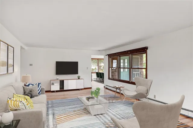 a living room with furniture a flat screen tv and a large window